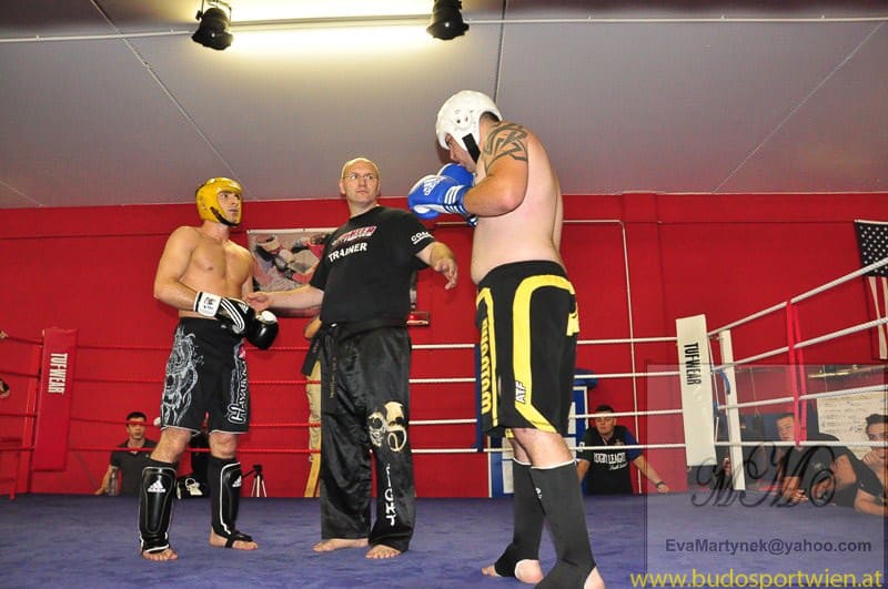 Zwei Kickboxer und ein Trainer im Boxring